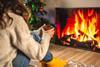 Woman sat cozily in from of a sitting room fire