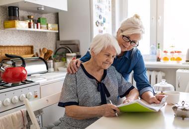 Older lady looking at paperwork in a kitchen