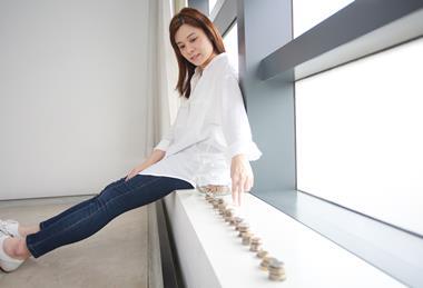 Woman sat on windowsill counting change