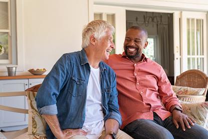 Younger man sat with older man laughing