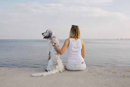 Woman and dog chilling on a beach