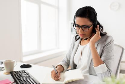 Woman at desk talking into a headset