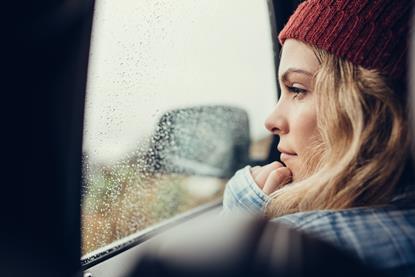 Young woman staring out a car window