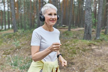 Middle ages lady running listening to headphones