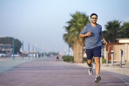 Man jogging down a  street on a sunny day