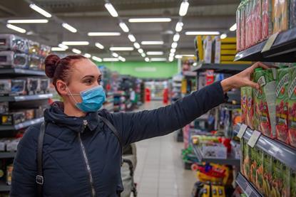 Woman shopping in a supermarket wearing mask