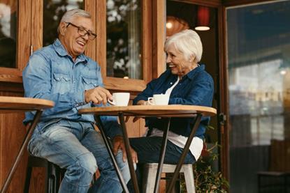 Older couple sat at a coffee shop laughing