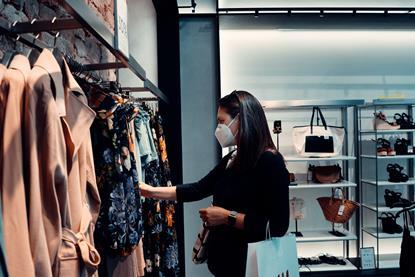 Woman wearing mask browsing in a clothing store