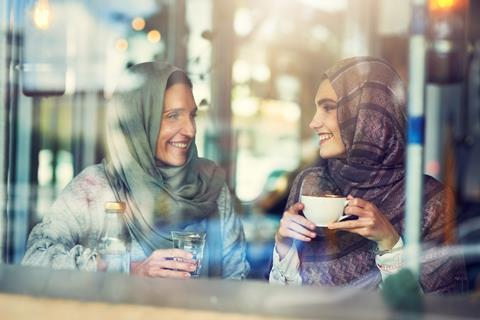 Two women sitting in a coffee shop chatting