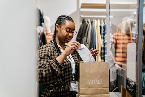 Cashier loading customers shopping into bag