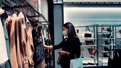 Woman wearing mask browsing in a clothing store