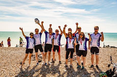 Team celebrating on the beach at the end of the bike ride